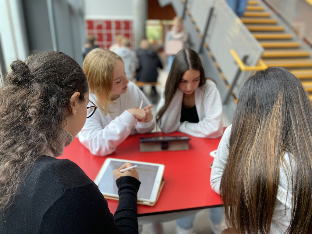 Schülerinnen und Schüler arbeiten im Unterricht mit iPads.