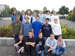 Die Klasse steht für ein Gruppenfoto auf dem Schulgelände.