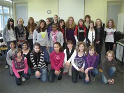 Die Teilnehmenden des Song-Contests stehen für ein Gruppenfoto im Klassenraum zusammen.