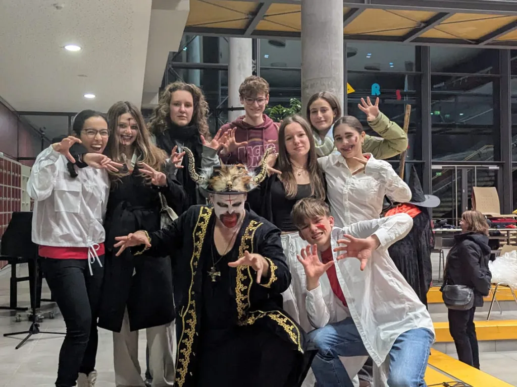 Eine Gruppe in Kostümen posiert für ein Foto in der Pausenhalle.