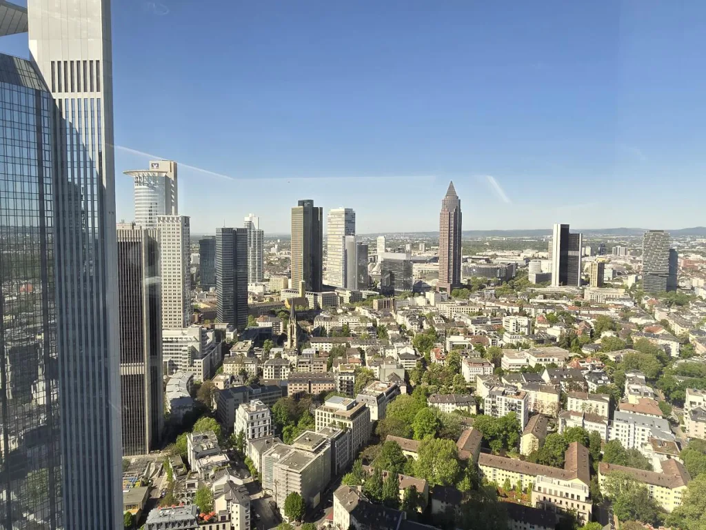 Blick aus großer Höhe über Frankfurt mit Bankentürmen und Wohnvierteln.