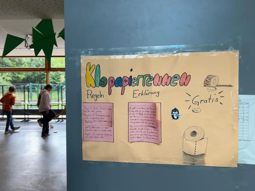 Ein Plakat mit der Aufschrift „Klopapierrennen“ erklärt Regeln und Ablauf.