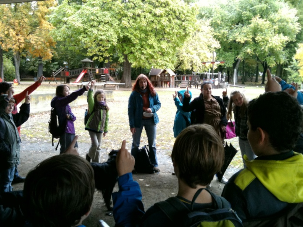 Eine Gruppe Kinder die etwas von einer Biologin erklärt bekommen