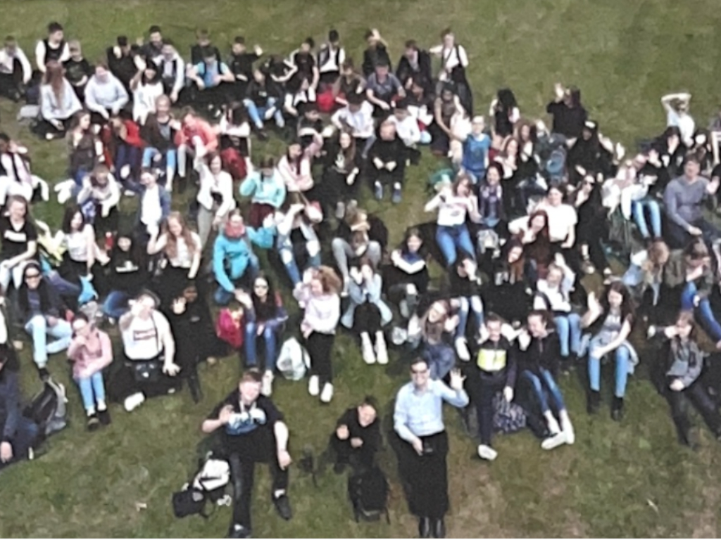 Schüler/innen mit Lehrkräften auf englischer Wiese